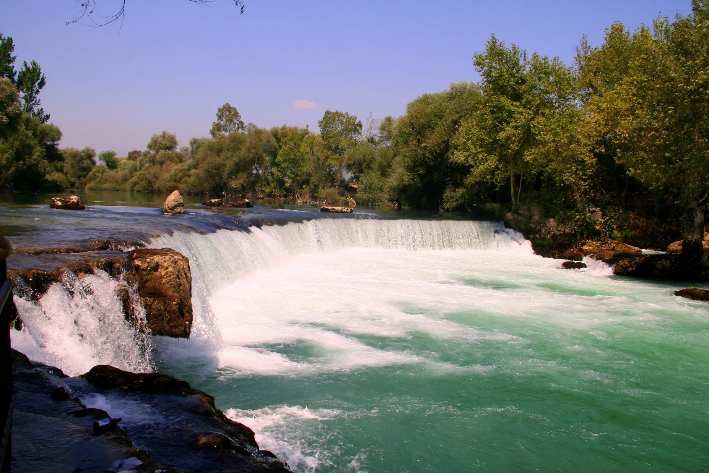 Der Manavgat-Wasserfall fällt als breiter weißer Vorhang über die Felsstufe des Flusses Manavgat