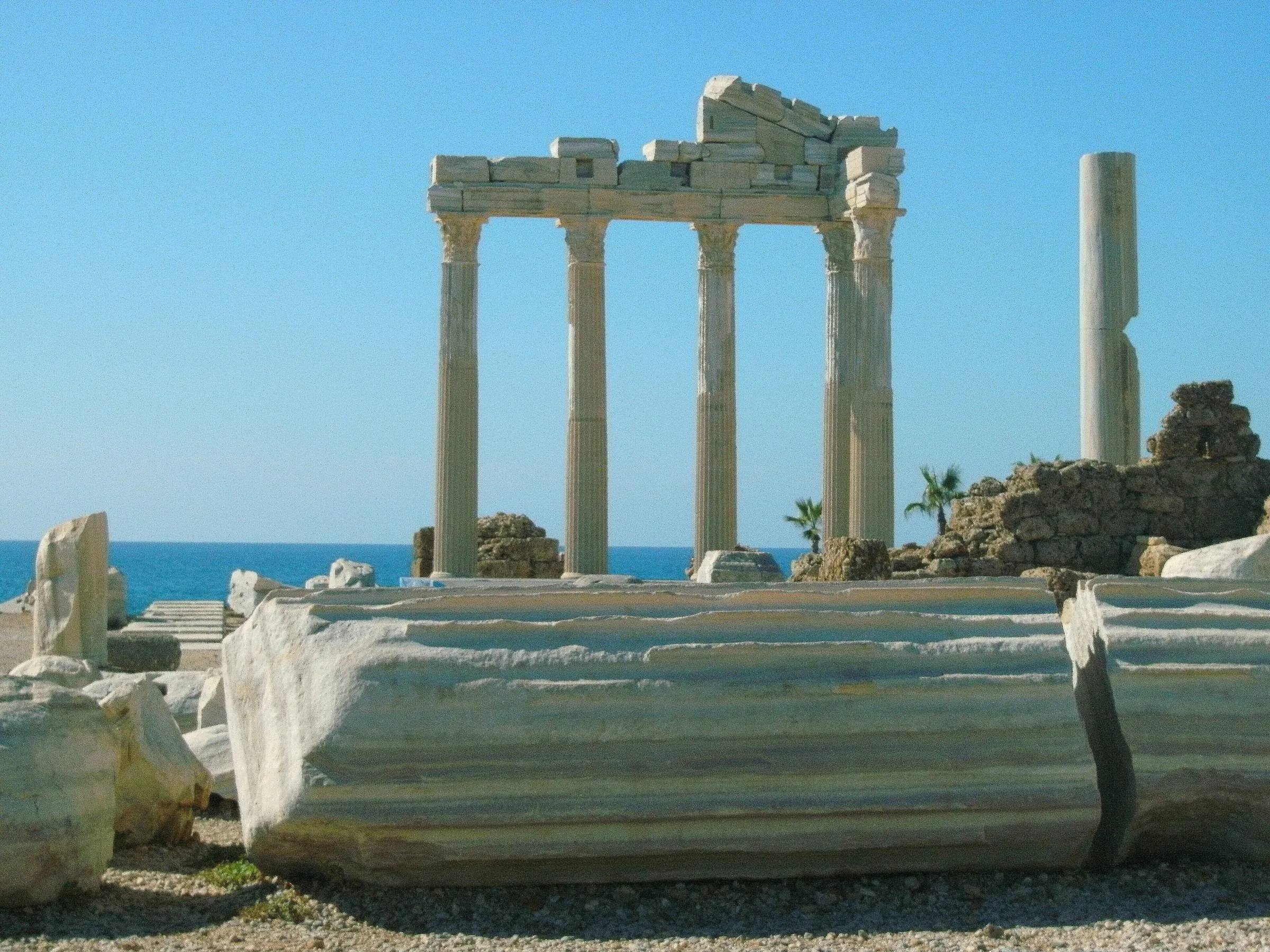 Die wieder aufgerichteten korinthischen Säulen des Apollon-Tempels auf der Landspitze von Side, davor eine liegende Säulentrommel, dahinter das Meer
